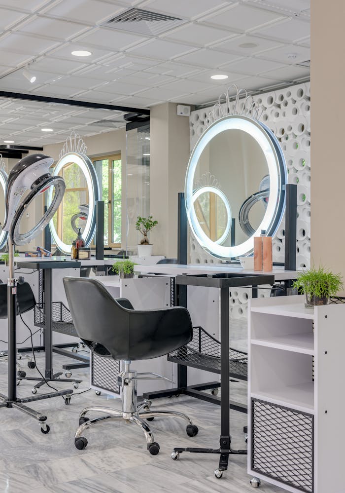Elegant hair salon interior featuring sleek design and illuminated mirrors for a stylish beauty experience.